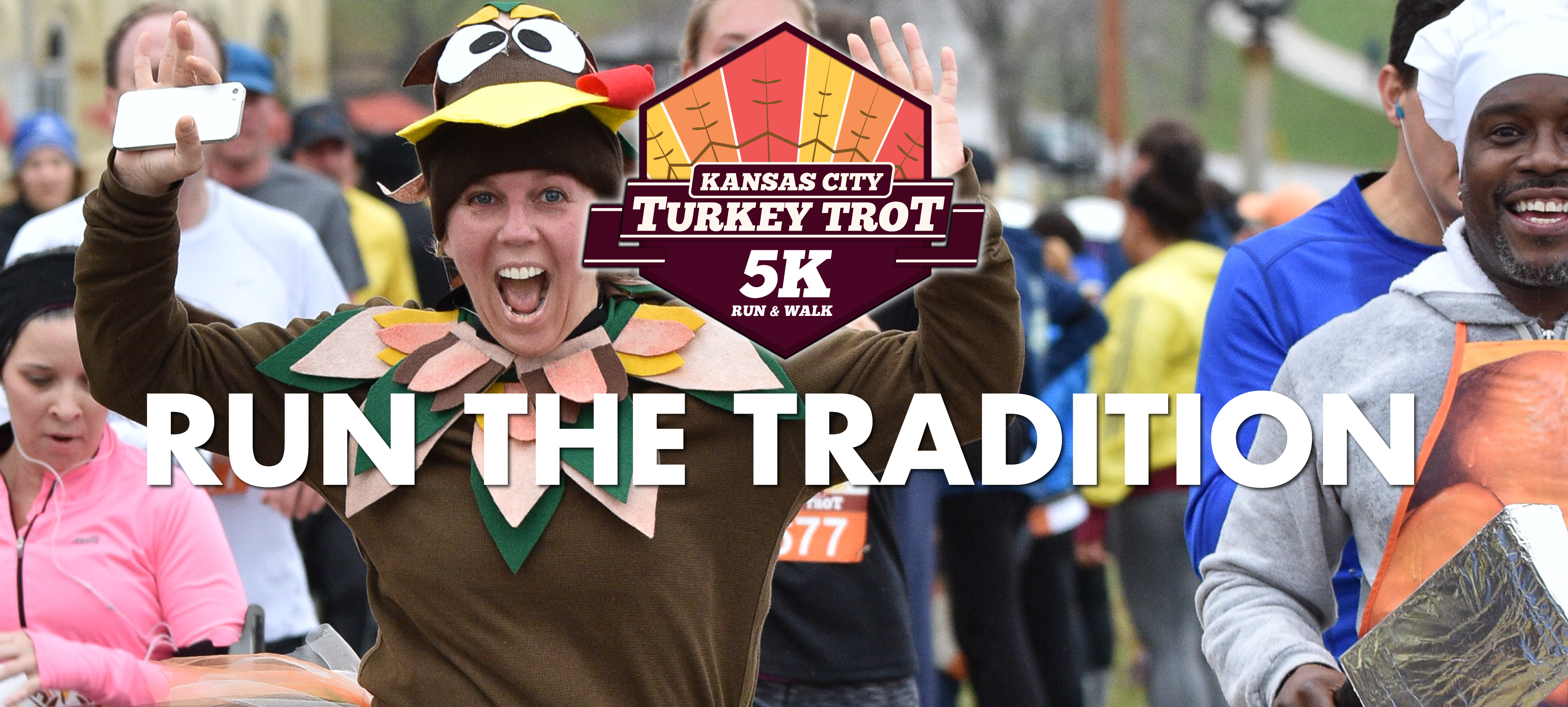 Participants crossing the finish at the Kansas City Turkey Trot — featuring event atmosphere and sponsor visibility.